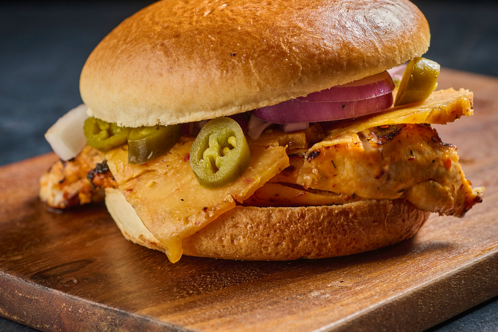 Chicken burger in a brioche bun with jalapeños and cheese